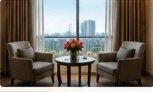 Lounge seating area with plush armchairs and city view